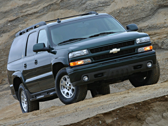 Image of a black used Chevy Suburban climbing up a rocky hill. 