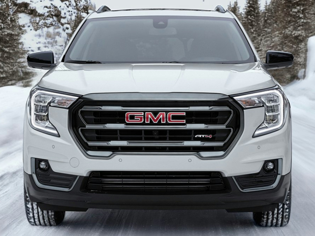 A white GMC driving in the snow